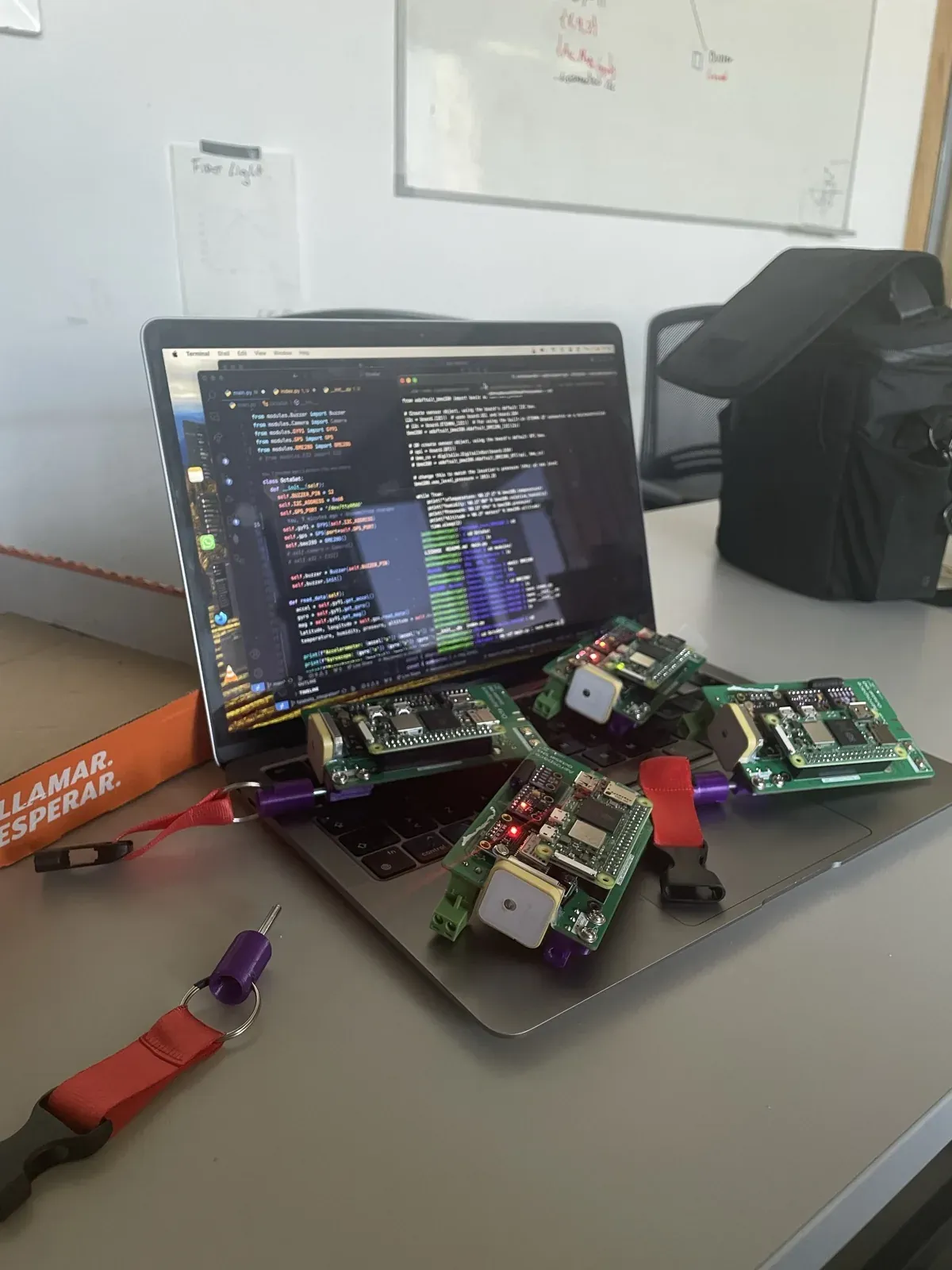 Four OctaSat flight boards resting on a laptop with their flight code open